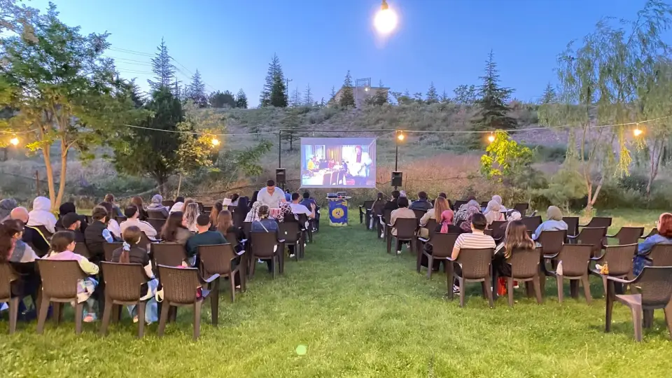 Geniş çimlikte sıralanmış sandalyeler ve film perdesi, Konya