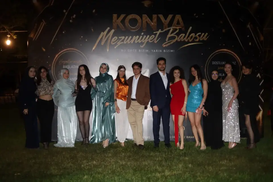 Mezuniyet balosu panosu önünde poz veren şık grup, Konya