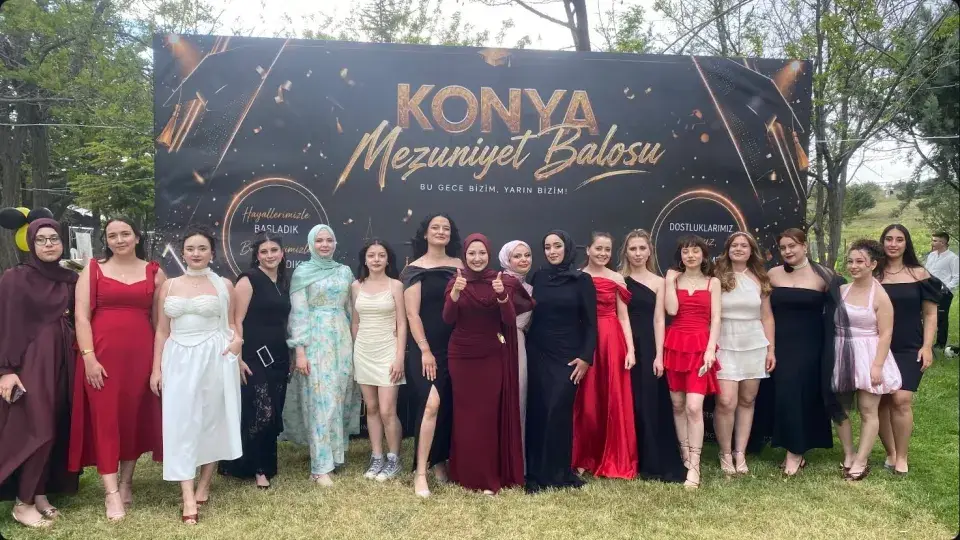 Mezuniyet balosu fonu önünde şık kıyafetli grup, Konya