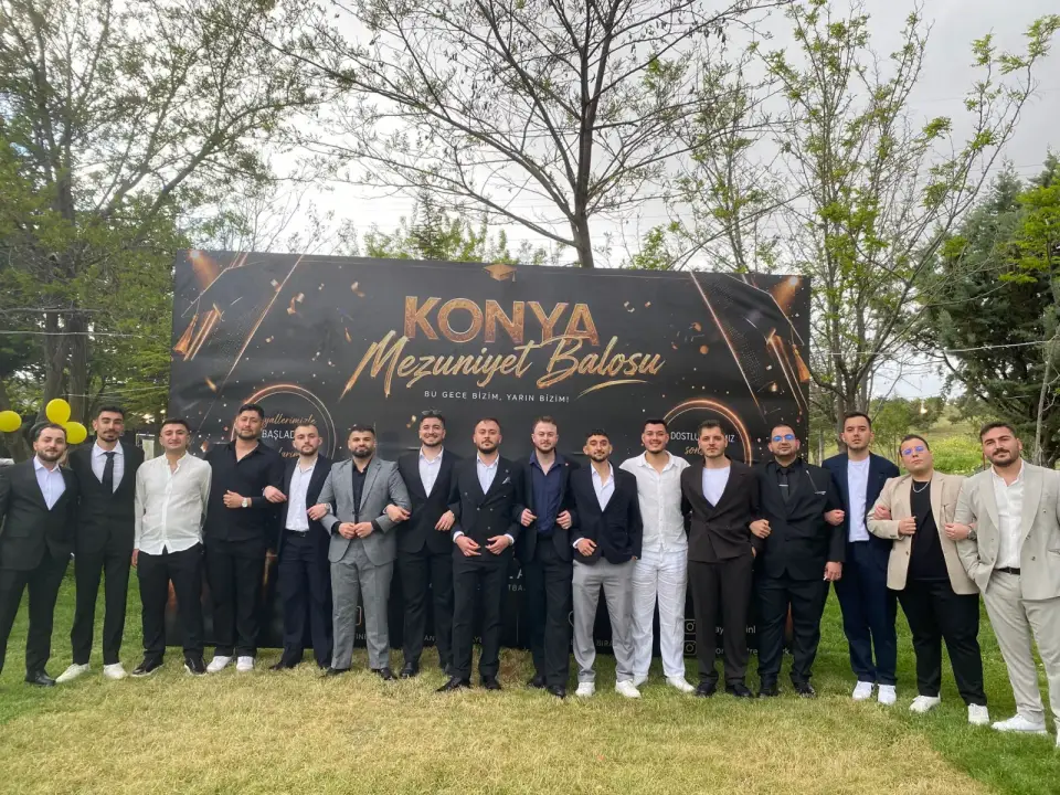 Bahçede mezuniyet balosu panosu önünde sıralanan grup, Konya