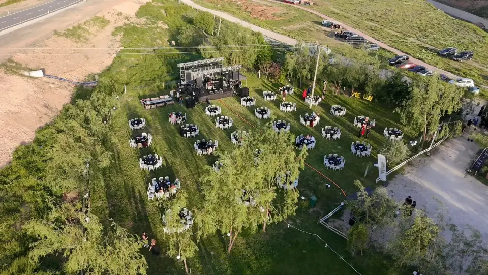 Çim alanda yuvarlak masalar ve sahne, havadan Konya
