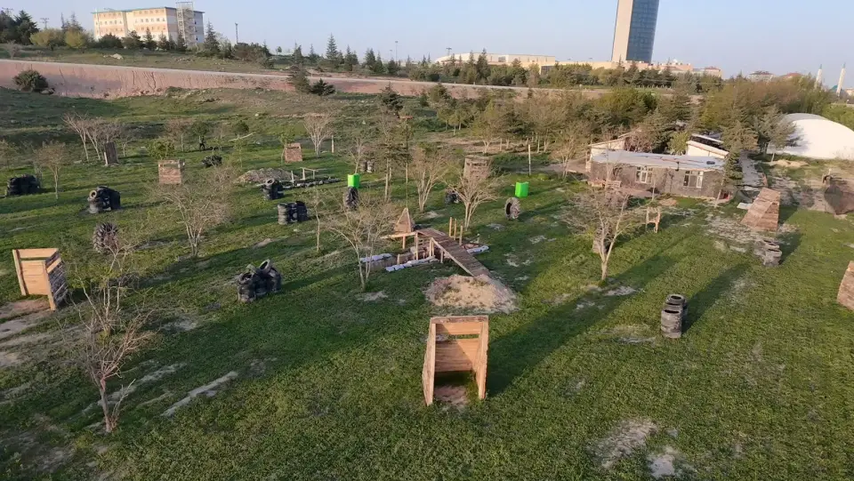 Ahşap ve lastik siperlerle dolu çimli paintball sahası, Konya