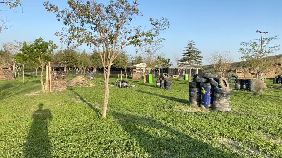 Ağaçlar ve lastik siperlerle akşam paintball sahası, Konya