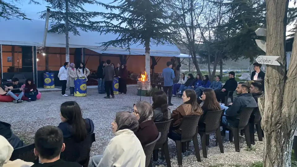 Akşam çakıllı alanda sandalyelerde oturan etkinlik katılımcıları, Konya