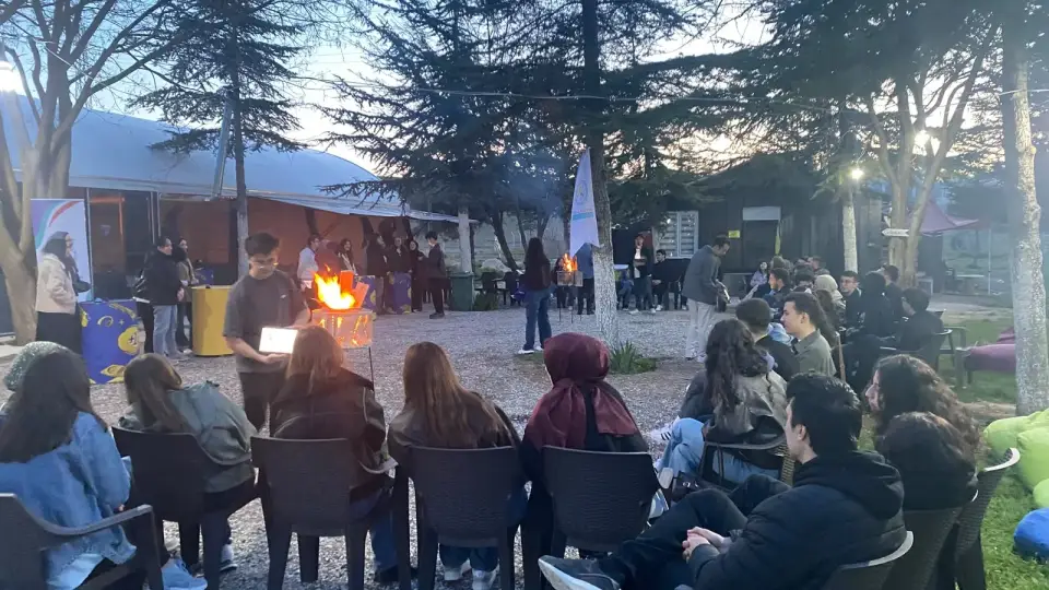 Ateş yakılmış alanda sandalyelerde toplanan topluluk, Konya